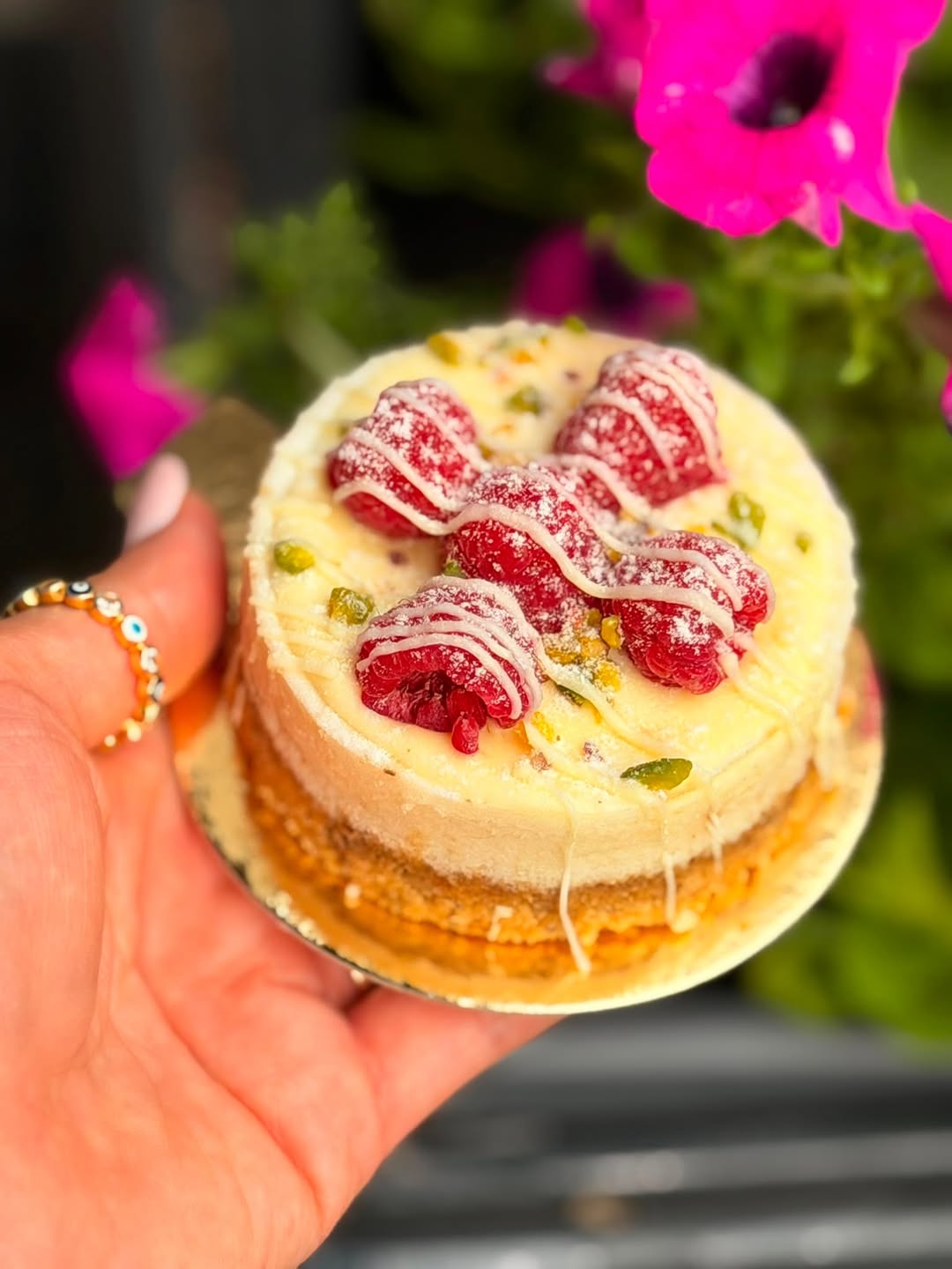 Mini-Cheesecake mit Himbeeren in der Hand